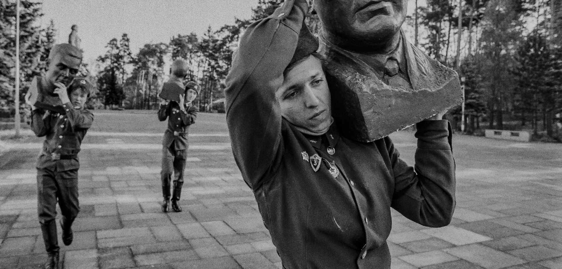 drei Soldaten tragen Köpfe von Statuen weg
